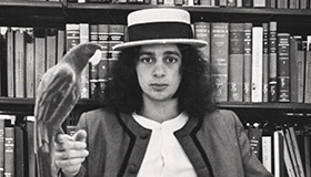 Photo from UW-Archives of a student holding a bird in a library.