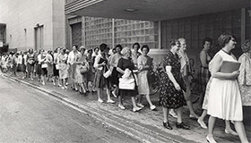 Throwback image of women lined up outside of a building on the UW-Madison campus.