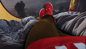 Bucky Badger laying down in a tent.