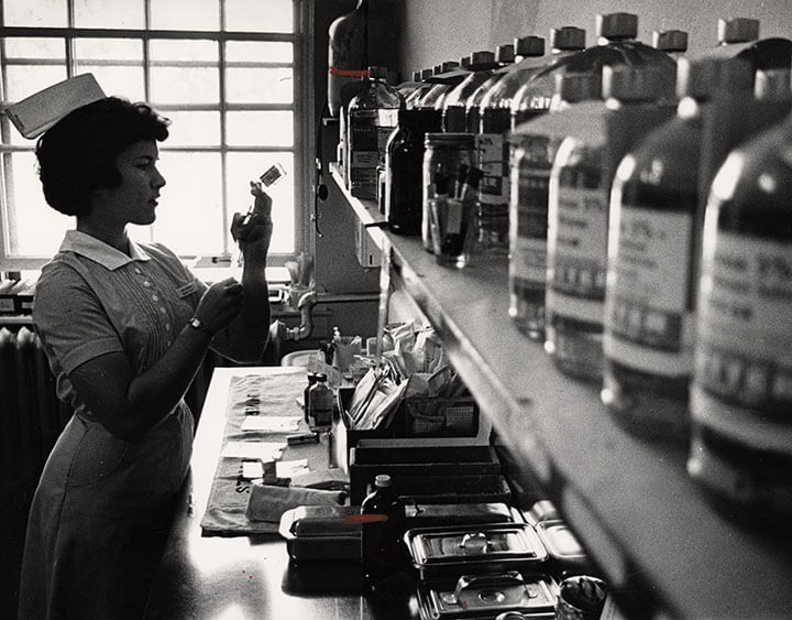 Black and white photo of nurse working in lab.