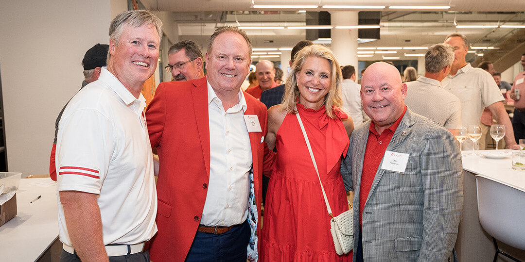 Buckingham Club speakers and guests in Badger red attire gather for a photo.