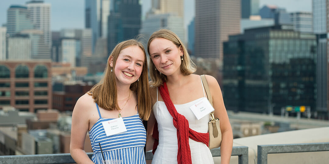 Two young women enjoy the Minneapolis skyline from the roof of The Nordic.